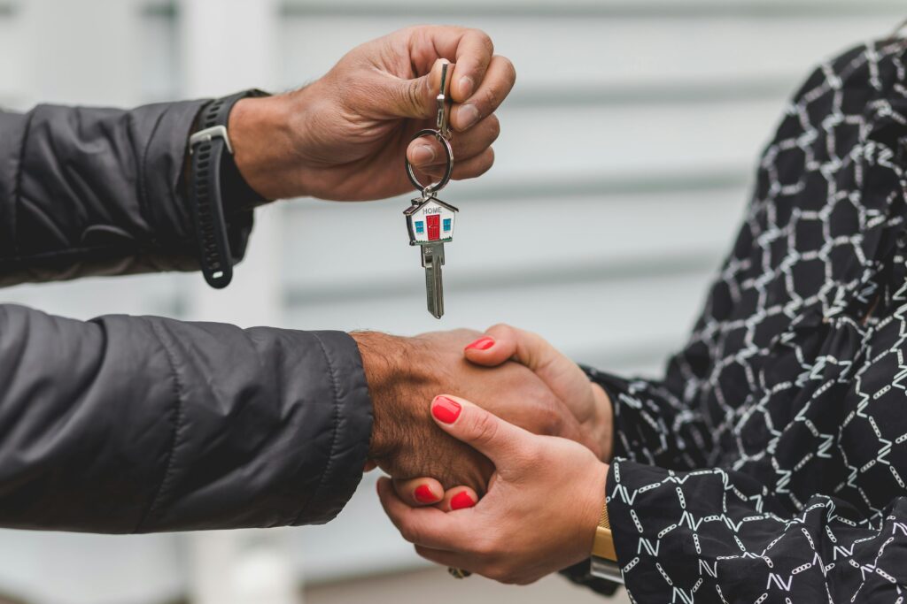 pexels photo 8293778 8293778 Close-up of a realtor handing over a house key to a new homeowner, symbolizing ownership and investment.